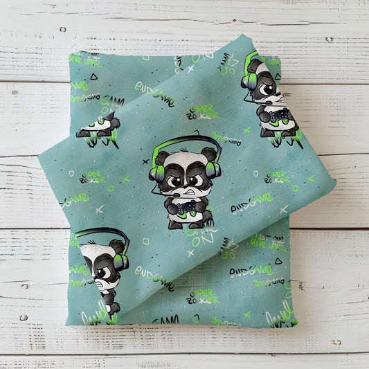 Gefalteter Kinderstoff Gamepanda von Schnubbirella im Mockup – mintfarbener Hintergrund mit Panda-Gamer-Motiv, Headset, Controller und Gamer-Schriftzügen, drapiert auf dunkelgrünem Kombistoff.