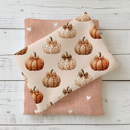 Herbststoff „Gepunktete Kürbisse“ mit Kürbissen in Beige, Creme und Orange, verziert mit Punkten und Schleife.