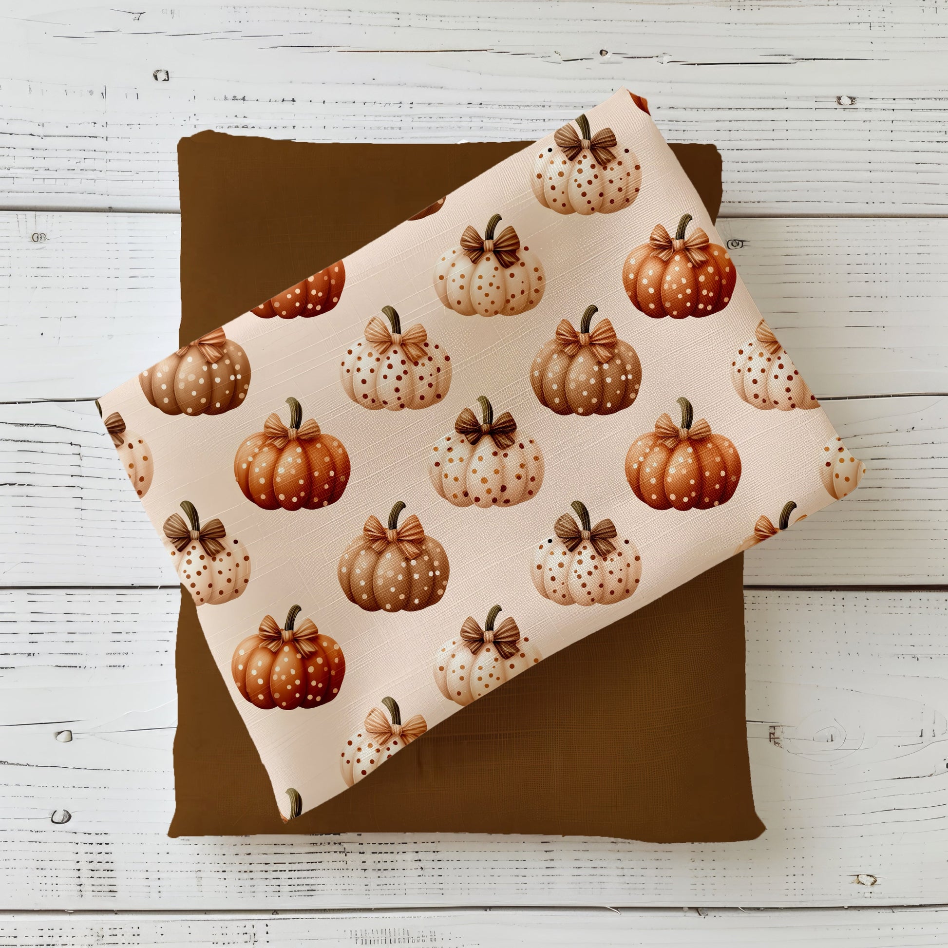 Herbststoff „Gepunktete Kürbisse“ mit Kürbissen in Beige, Creme und Orange, verziert mit Punkten und Schleife.