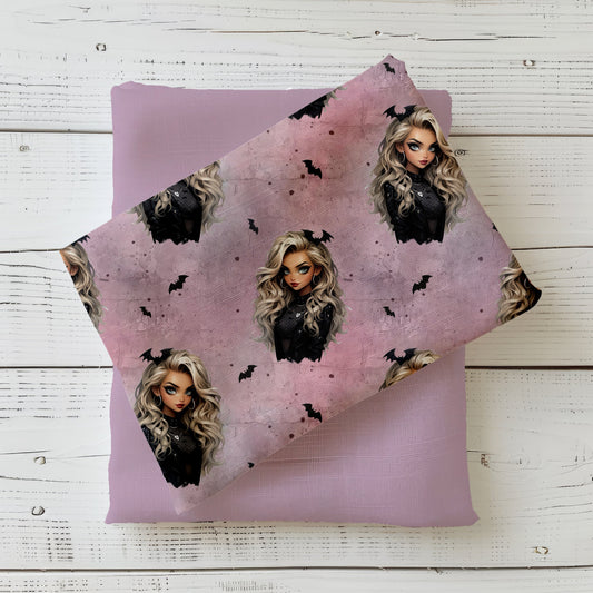 Nahtloses Stoffmuster mit dem Design  "Gothic Glam" in rosa – eine Frau mit lockigen blonden Haaren mit Fledermaus im Haar, schwarz gekleidet auf einem rosafarbenen Hintergrund in Beton Optik mit Rissen. Kleine schwarze Fledermäuse und weiße herzen befinden sich in den Zwischenräumen.