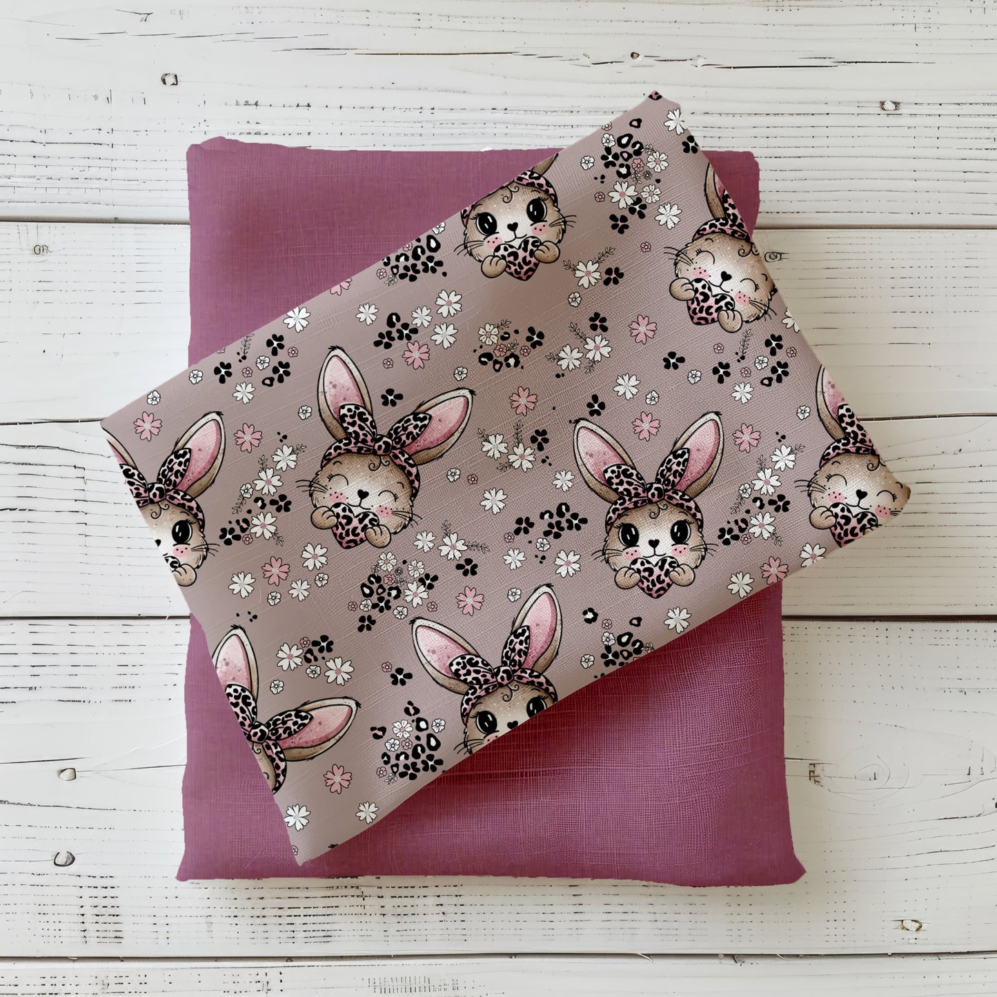 Stoffdesign „Häschen“ mit niedlichen Hasenmotiven, Blumen und Herzchen in warmen Rosé- und Naturtönen, dekorativ gefaltet auf hellem Hintergrund.