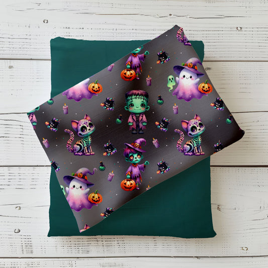 Halloweenstoff „Halloween Crew“ mit Geistern, Hexenmädchen, Frankenstein, Skelettkatze und Kürbissen auf dunklem Hintergrund.