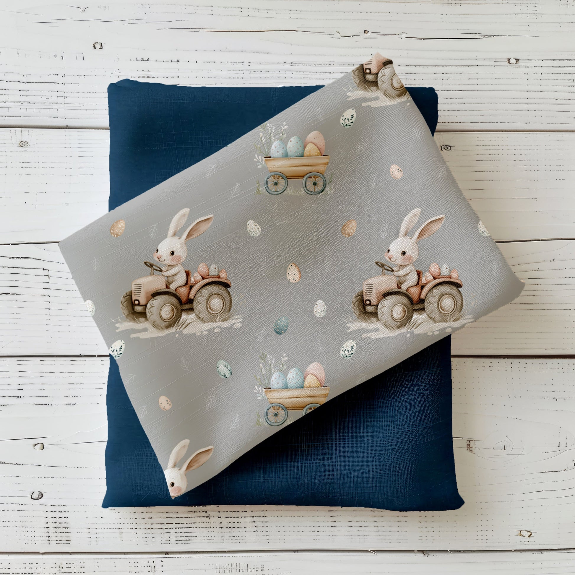 Hasenfahrt Nebelgrau Stoff mit Häschen auf Traktor, Ostereiern und floralen Details auf grauem Hintergrund