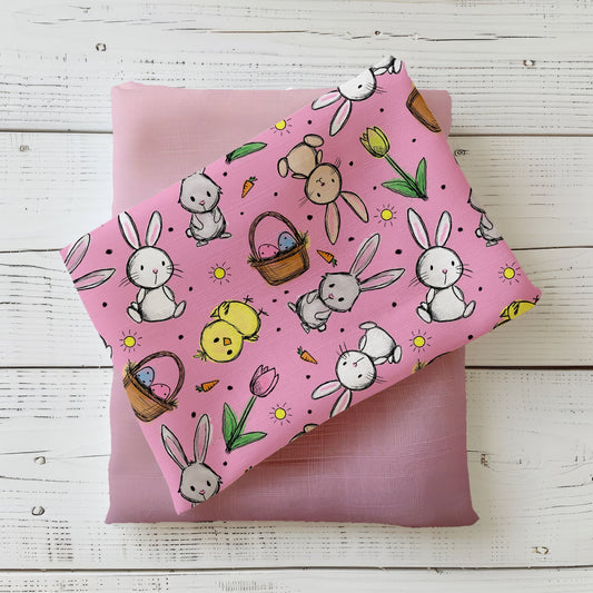 Hasenglück Rosé Stoffdesign mit Hasen, Küken, Ostereiern, Karotten und Tulpen auf rosafarbenem Hintergrund