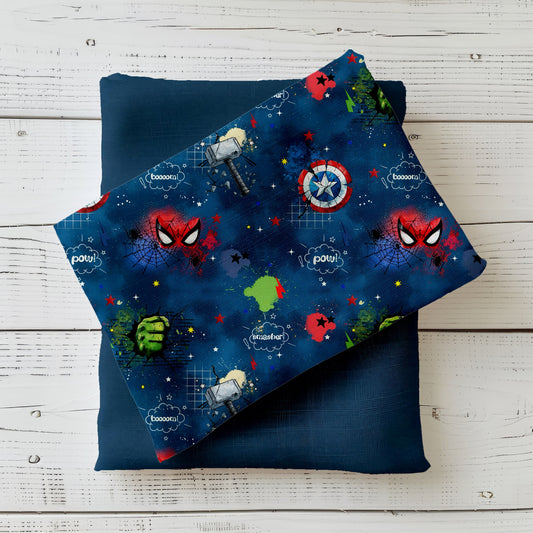 Comic-Stoff mit Superhelden-Motiven – Maske, Schild & Faust auf blauem Hintergrund.