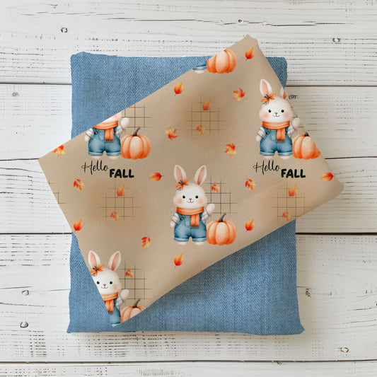 Herbststoff „Herbsthäschen – Hello Fall“ mit Hase, Kürbis, fallenden Blättern und Schriftzug auf beigem Hintergrund.