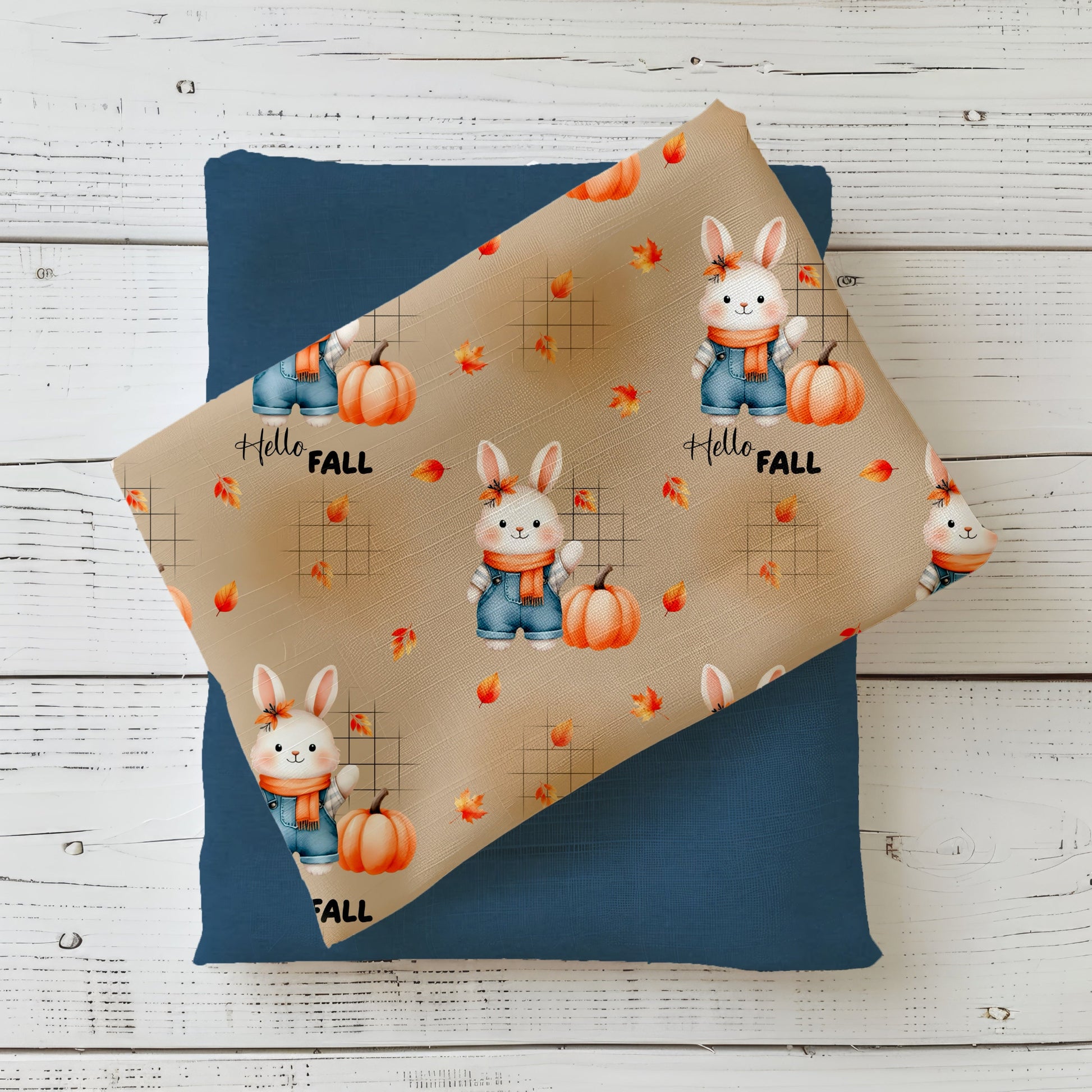 Herbststoff „Herbsthäschen – Hello Fall“ mit Hase, Kürbis, fallenden Blättern und Schriftzug auf beigem Hintergrund.