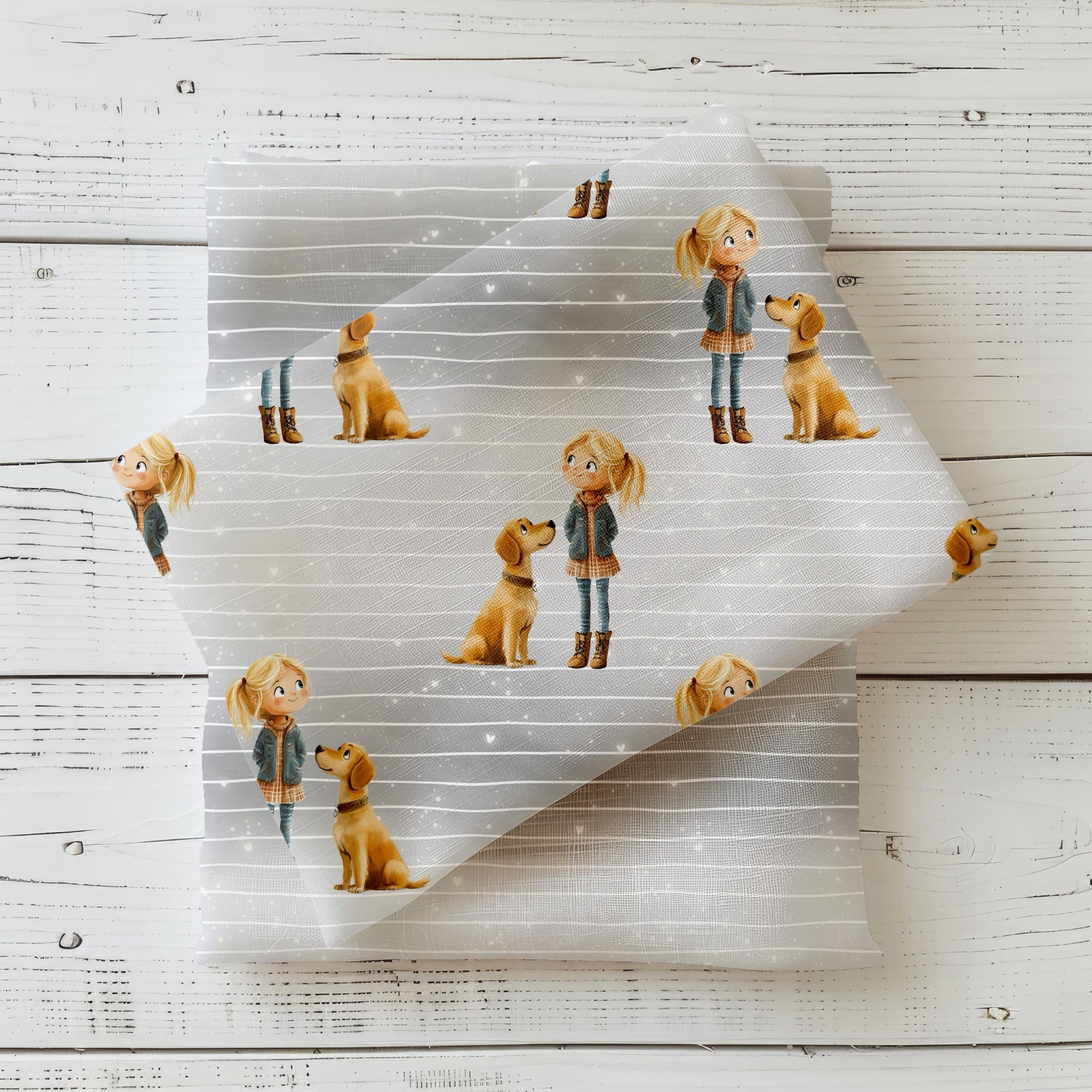 Gefalteter Hundeliebe Stoff – Mädchen-und-Hund Motiv auf sanftem grauen Linienhintergrund mit dezenten Glitzerpunkten, dekorativ auf hellem Holz präsentiert
