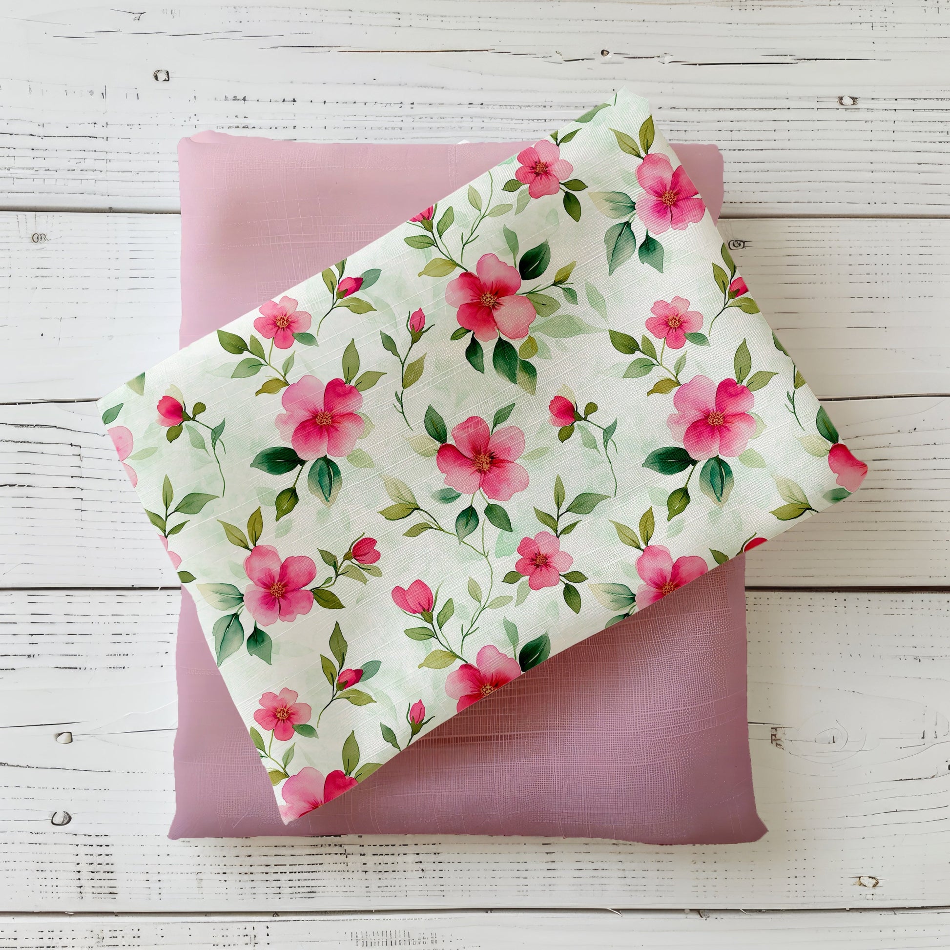 Gefalteter Stoff „Kleine Blümchen“ mit rosa Blüten auf hellem Hintergrund, präsentiert auf roséfarbenem Kombistoff.