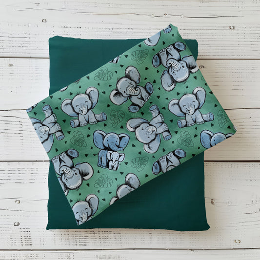 Gefalteter Stoff mit Baby-Elefanten auf grünem Untergrund – Design „Kleiner Elefantentraum“ für Jersey & French Terry.