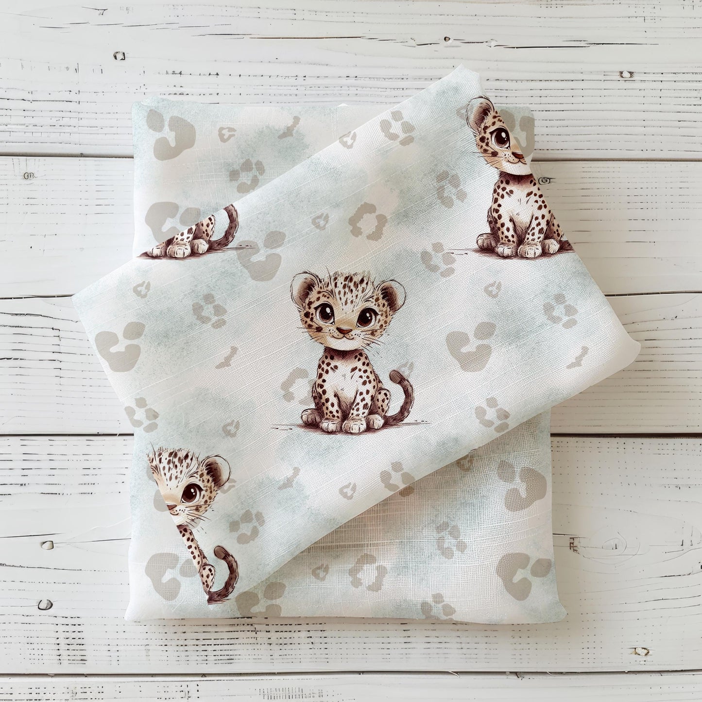 Kinderstoff „Kleiner Leopard“ als genähtes Set, gezeigt im Mockup mit süßen Leoparden-Babys in Beige-Mint-Aquarelloptik.