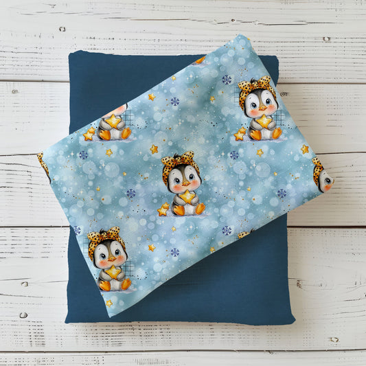 Winterstoff „Kleiner Pinguin“ mit Pinguin, Schneeflocken und Sternen auf blauem Hintergrund.