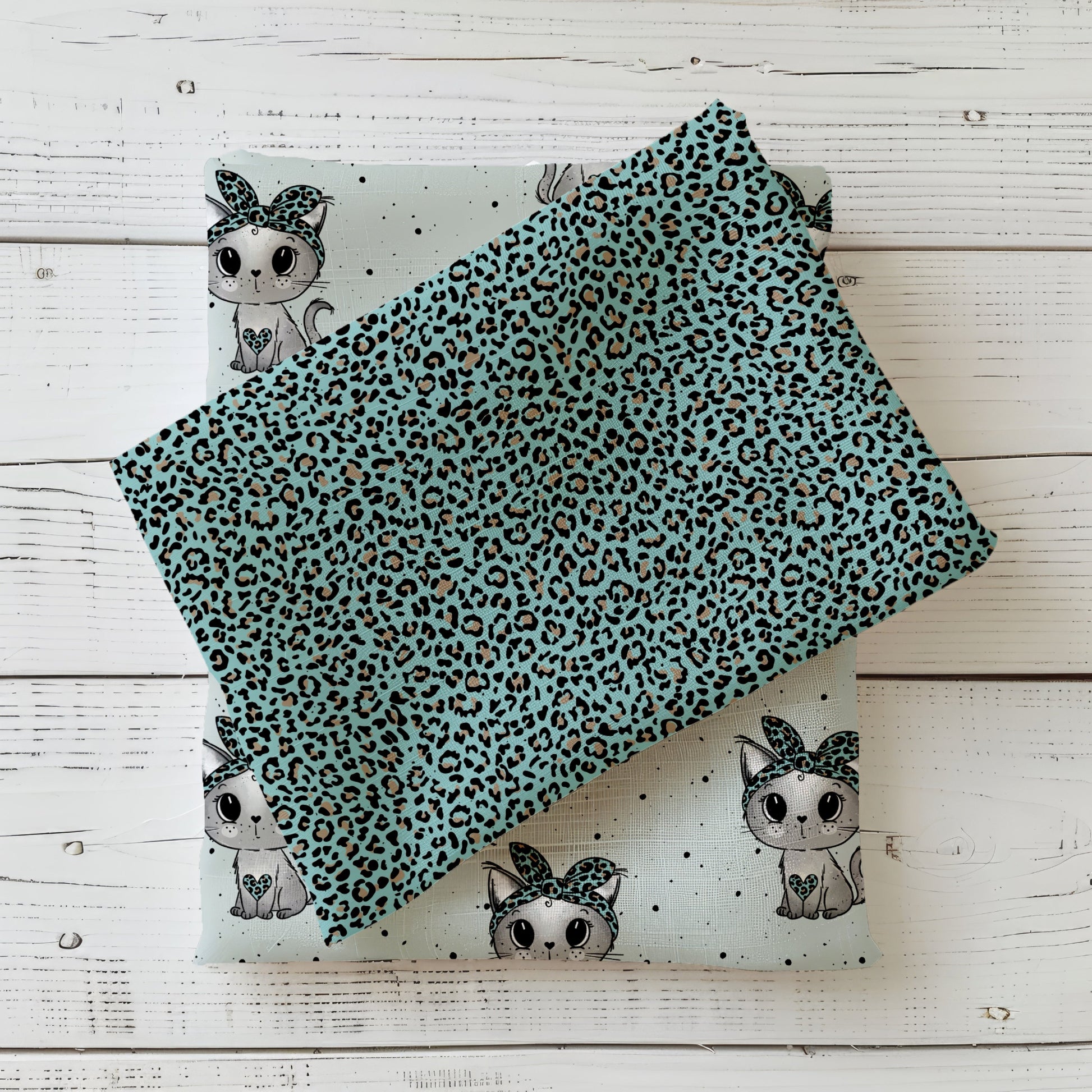 türkis-schwarzer Leopardenstoff auf Kinderstoff mit süßen Kätzchen, Kombistoff für Leo Kitty auf weißem Holzhintergrund