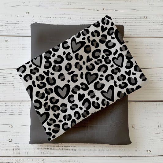 Gefalteter Stoff „Leo Herzen grau“ mit schwarzem Leopardenmuster und Herzmotiven auf grauem Hintergrund, dekorativ auf uni Kombistoff arrangiert
