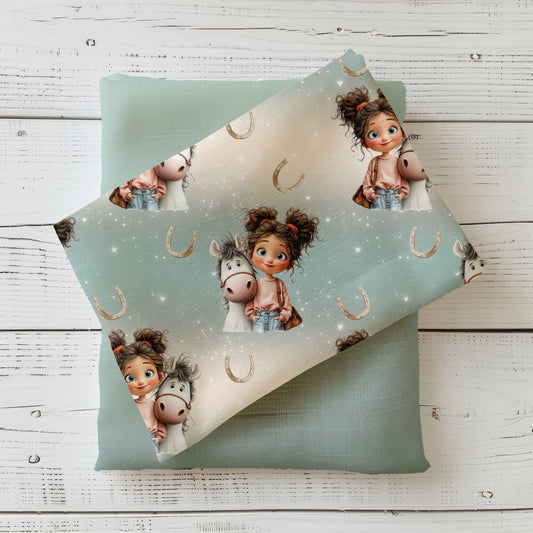 Pferde Kinderstoff Little Horse Love dekorativ auf hellem Holzhintergrund drapiert – zarter Mädchenstoff in Beige und Mint
