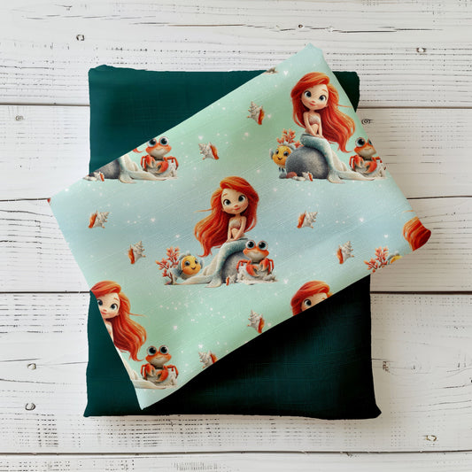 Design „Meereszauber“ mit kleiner Meerjungfrau, Krebs, Fisch und Korallen auf türkisfarbenem Hintergrund