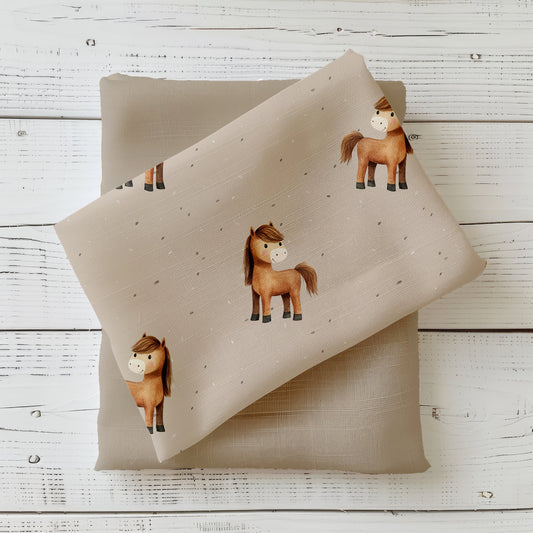 Mockup: Stoff „Pferdchen“ – beige/taupener Grund mit kleinen braunen Ponys und feinen Sprenkeln; Stoffkachel diagonal auf passendem Uni in Sand/Taupe als Kombi.