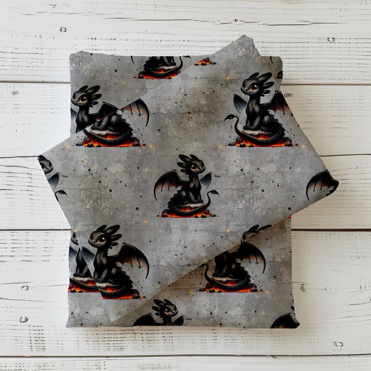 Gefalteter Stoff mit schwarzem Drachen auf Lava mit grauem Fantasy-Hintergrund.