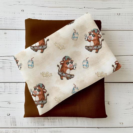 Stoff mit Kuh auf Skateboard und Milchdetails für moderne Kinderkleidung