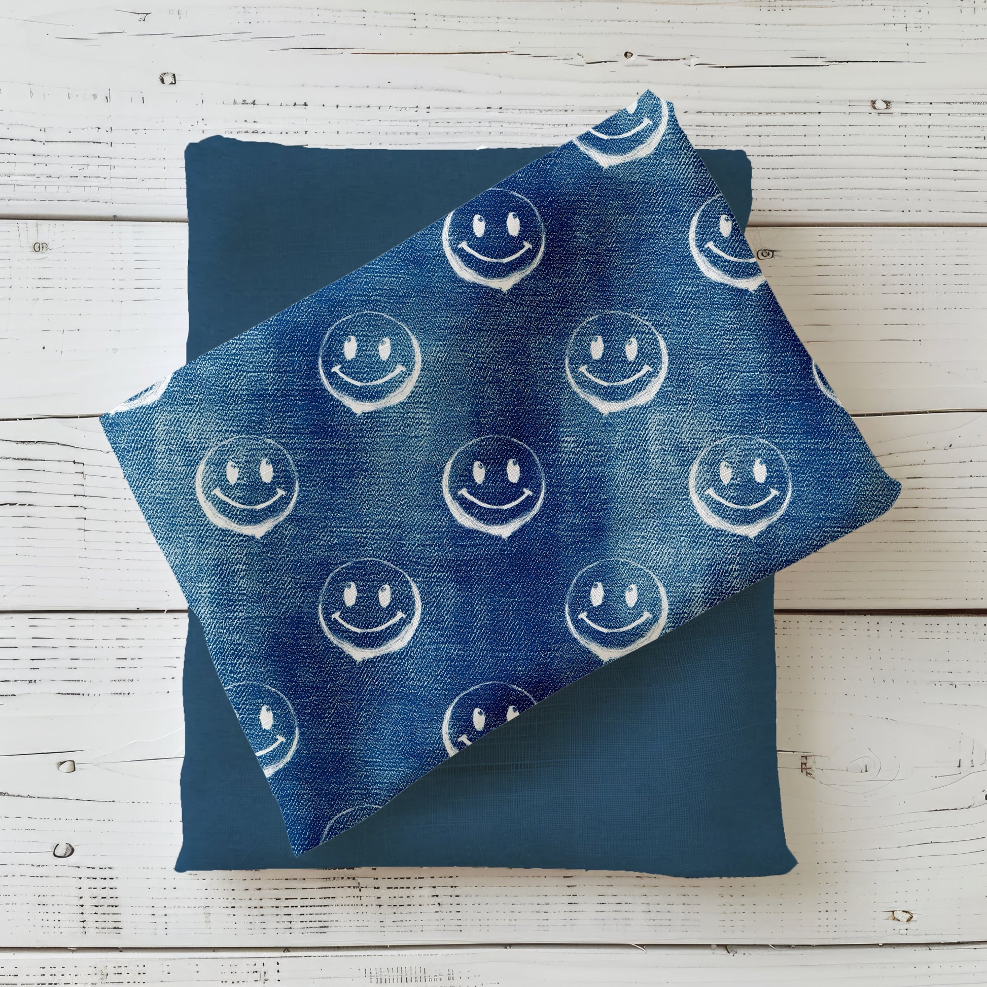 Gefalteter Stoff des Designs „Smiley – Denim blau“ mit durchgehendem Smiley-Muster.