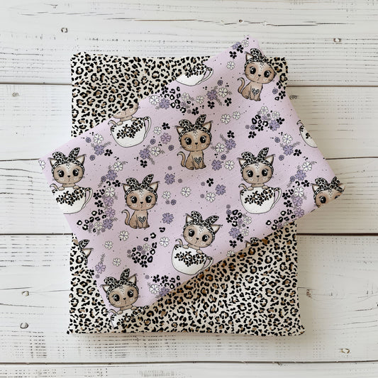 Fliederfarbener Stoff mit niedlichen Kätzchen in Tassen und Leo-Schleifchen, kombiniert mit Leomuster-Jersey – Design „Tassenkitty“ von Katzengold-Designs.