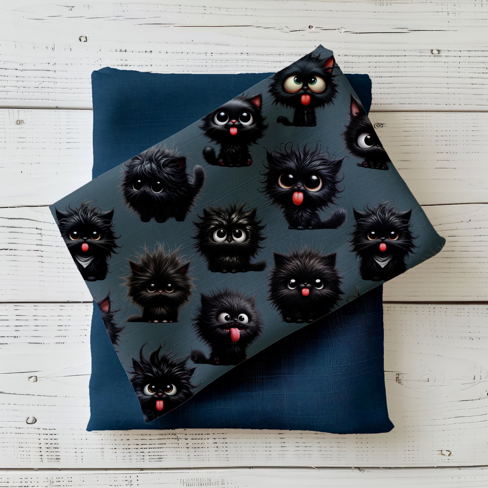 Verrückte Kätzchen Stoff dekorativ drapiert auf hellem Holzhintergrund – schwarzes Katzen Design auf petroligem Hintergrund