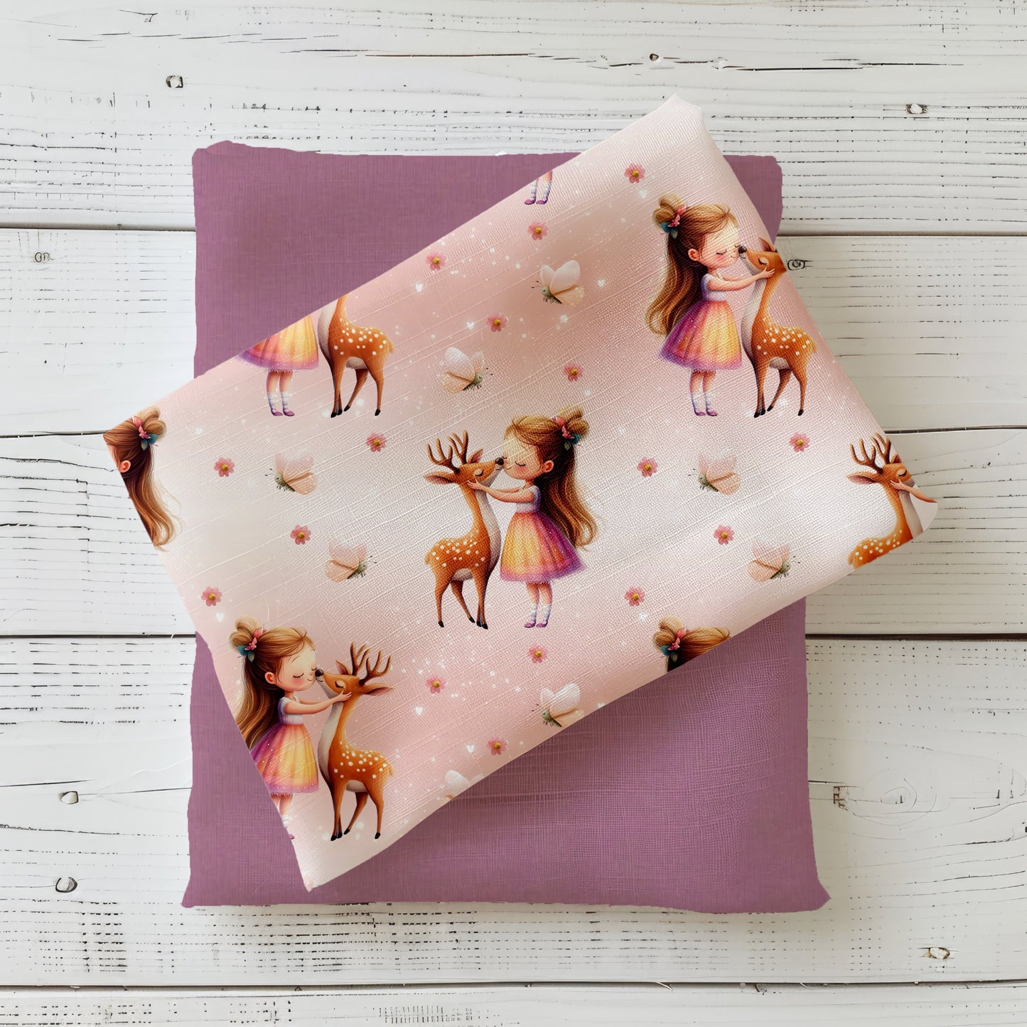 Gefalteter Waldmädchen Stoff – Mädchen-und-Rehlein Motiv auf rosigem Pastellhintergrund mit feinen Lichtpunkten und Blüten, dekorativ auf Altrosa-Kombistoff präsentiert