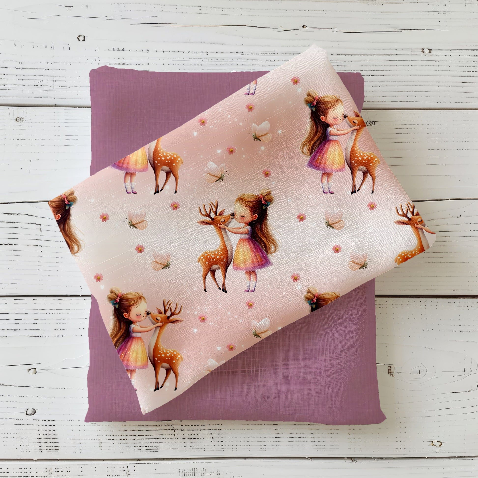 Gefalteter Waldmädchen Stoff – Mädchen-und-Rehlein Motiv auf rosigem Pastellhintergrund mit feinen Lichtpunkten und Blüten, dekorativ auf Altrosa-Kombistoff präsentiert