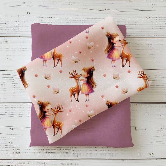 Gefalteter Waldmädchen Stoff – Mädchen-und-Rehlein Motiv auf rosigem Pastellhintergrund mit feinen Lichtpunkten und Blüten, dekorativ auf Altrosa-Kombistoff präsentiert