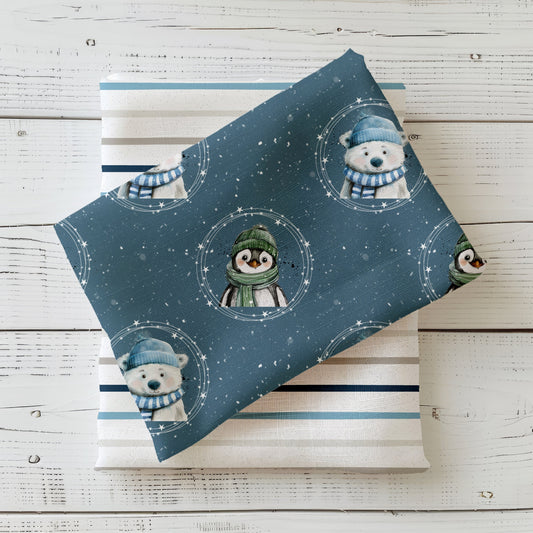 Winterstoff „Weihnachtsfreunde“ mit Pinguin im grünen Schal und Eisbär mit blauer Mütze vor Schneehintergrund.