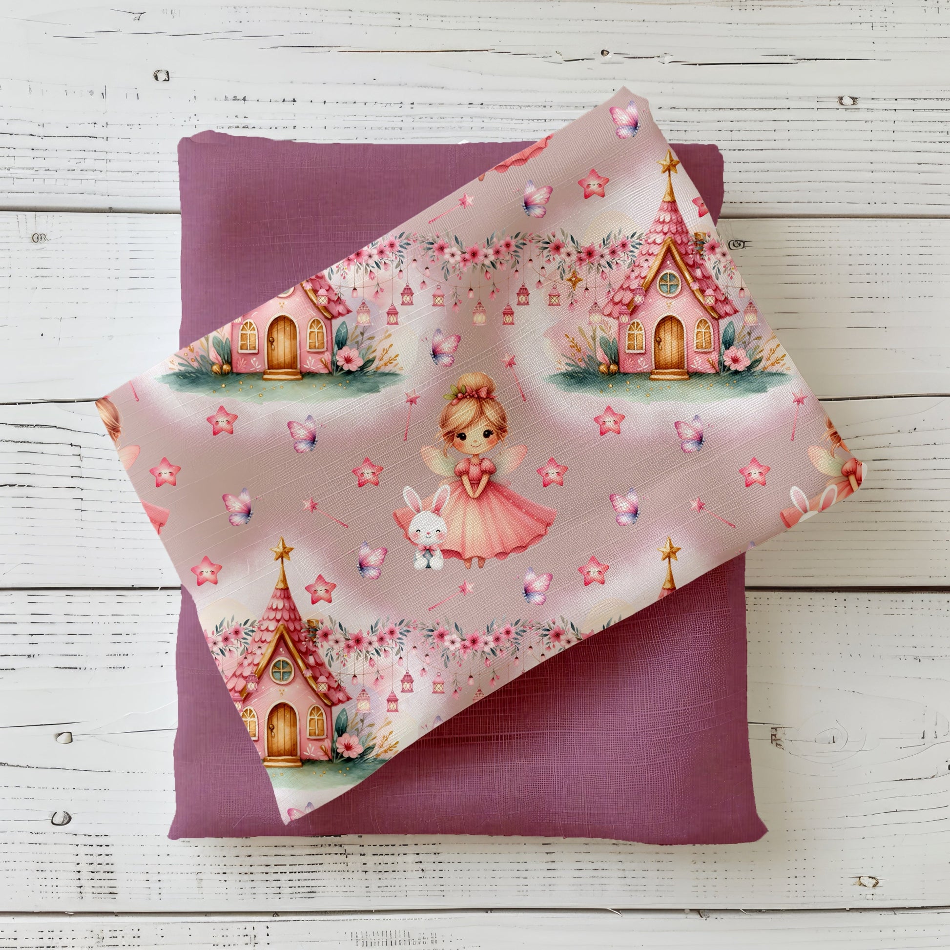 Stoff-Mockup „Zauberhafte Fee“ – rosa Kinderstoff mit kleiner Fee, Häschen, Märchenhäusern, Sternen und Schmetterlingen, drapiert auf farblich passendem Uni-Stoff.