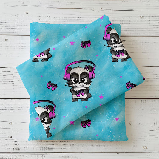 Mockup eines türkisfarbenen Kinderstoffs ‚Zockerpandi‘ von Schnubbirella, mit Gaming-Panda, Kopfhörern und Controller, drapiert auf dunklem Kombistoff.