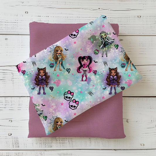 Halloweenstoff „Zombelicious“ mit Monster-Girls, Totenköpfen und Spinnennetzen auf pastellfarbenem Hintergrund.