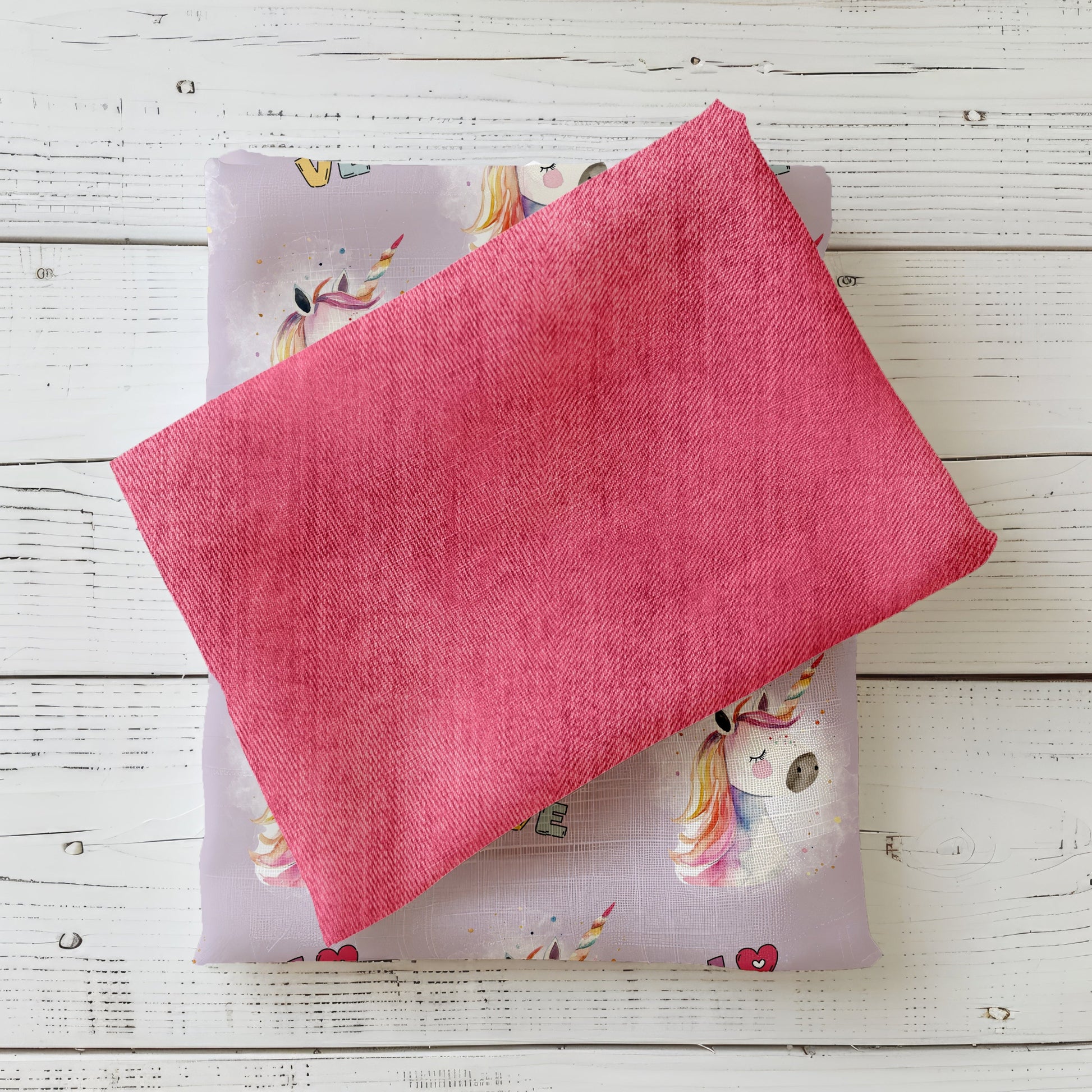 Gefalteter Denim Pink Kombistoff auf hellem Untergrund – ideal für Kleidung.