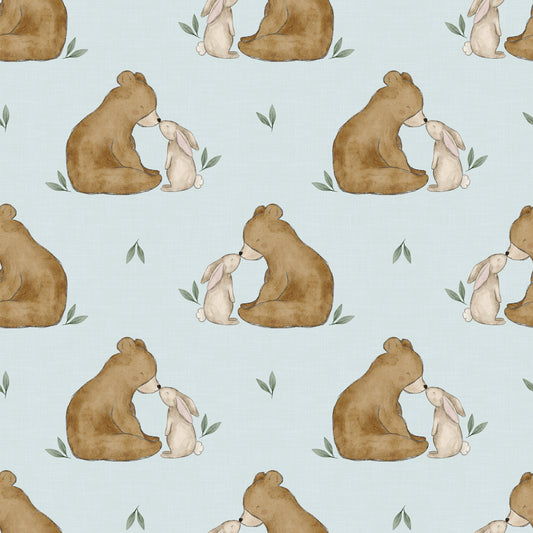 Detailansicht Kinderstoff mit Bär-und-Hase-Motiv in Naturtönen, flach gefaltet auf Holzhintergrund