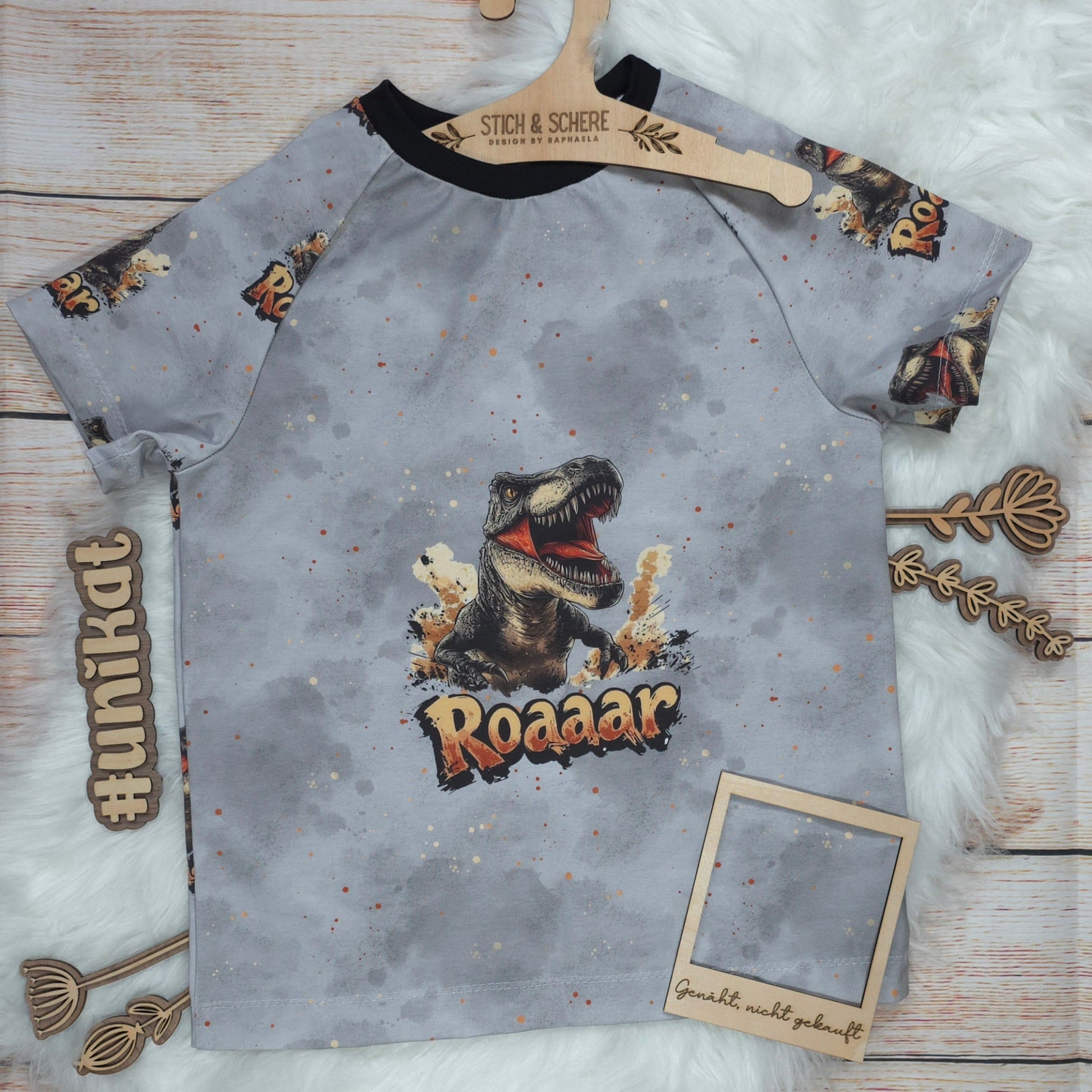 Vorderseite des handgenähten Kinder T-Shirts T-Rex in Größe 122 mit großem T-Rex-Motiv und Roaaar-Schriftzug auf grauem Hintergrund