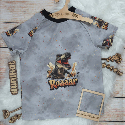 Vorderseite des handgenähten Kinder T-Shirts T-Rex in Größe 122 mit großem T-Rex-Motiv und Roaaar-Schriftzug auf grauem Hintergrund